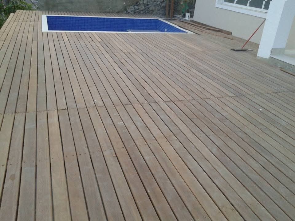 Deck de madeira e piscina de azulejo azul executados pela AJR